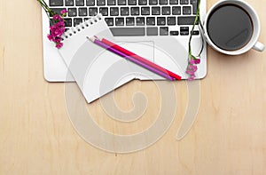 Stylized women`s office desk. Workspace with, laptop, Flower branch and coffee cup