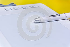 Stylus pen and graphic tablet for digital design work. Close-up of a tablet and digital pen