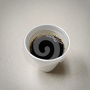 Styrofoam Cup of Black Coffee on Breakroom Table photo