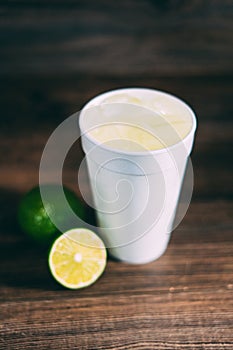 A styrofoam cup and a citrus fruit