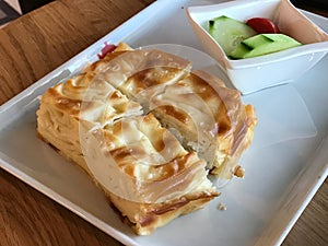 Su Boregi / Turkish Pastry Borek with tomatoes and cucumber served at restaurant.