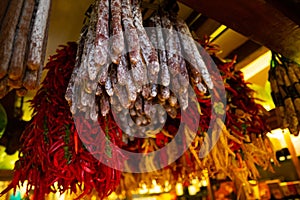 Suasages and peppers hanging outside at traditional rural market