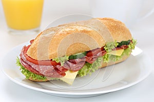 Sub deli sandwich baguette for breakfast with salami ham and ora