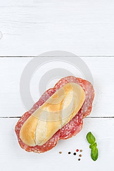 Sub sandwich with salami portrait format copyspace copy space from above on wooden board