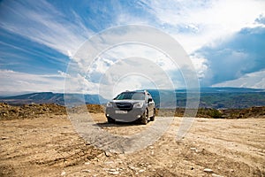 Subaru Forester car stand off road on desert dry land in mountains on blue sky