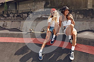Subculture. Girls On Skate Concrete Ramp At Skatepark Portrait. Female Hipsters Resting After Skateboarding. photo