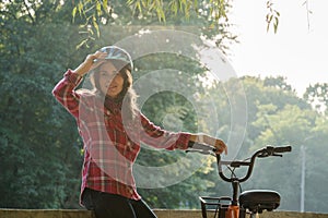 Subject ecological mode of transport bicycle. Beautiful young kasazy woman wearing a blue helmet and long hair poses standing next