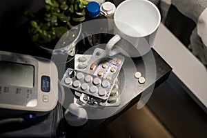Subject medicine health and pharmaceuticals. Close-up macro blood pressure monitor, a lot of blister packs with pills on the