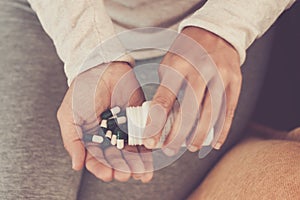 Subject medicine health and pharmaceuticals. Close-up macro young caucasian woman hands pulling out a green blister. Packing two