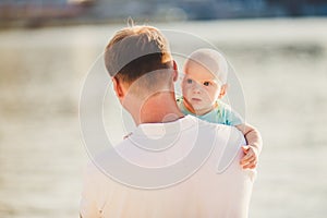 Subject Parenting, summer vacations, father and little son. Young Caucasian dad holds on arms, hugs child overlooking town Kiev