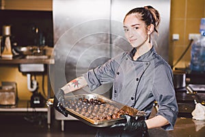 Subject profession and cooking pastry. young Caucasian woman with tattoo of pastry chef in kitchen of restaurant preparing round