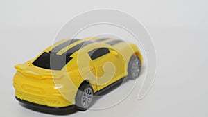 Subject shooting of a toy car. A model of a yellow sports car is on a spinning table.