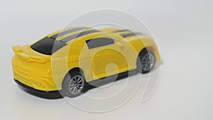 Subject shooting of a toy car. A model of a yellow sports car is on a spinning table.