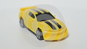 Subject shooting of a toy car. A model of a yellow sports car is on a spinning table.