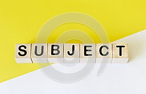 Subject symbol. Conceptual word Subject on wooden blocks. Beautiful white and yellow background, copy space. Business and subject