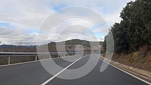 Subjective view of a vehicle tracing curves through the Bierzo mountains with wet asphalt