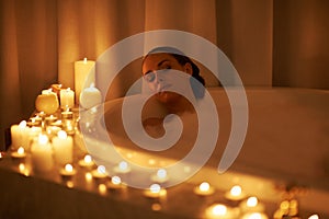 Sublime ambient relaxation. a gorgeous woman relaxing in a candle lit bath.