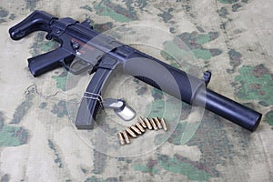 submachine gun MP5 with silencer on camouflaged
