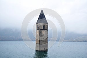 Submerged tower of reschensee church deep in Resias Lake of Bolzano or bozen, Italy