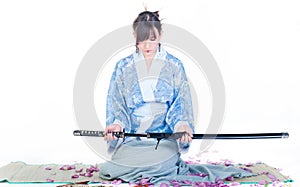 Submissive geisha in blue kimono with katana
