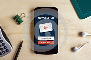 Subscribe newsletter concept on smart phone screen on wooden desk