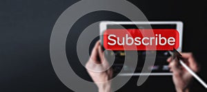 Subscription service. Online video red subscribe button. Internet service on laptop digital tablet blured banner