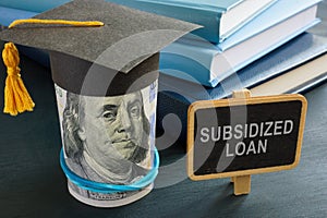 Subsidized loan sign and student graduation cap.