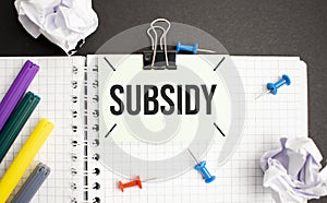 subsidy word written on wood block. reduction word is made of wooden building blocks lying on the blue table. Business concept