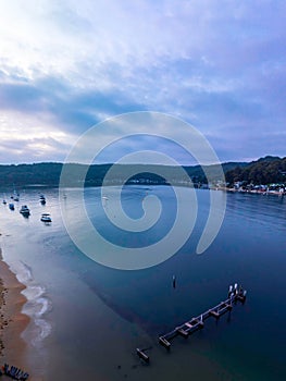 A subtle sunrise waterscape with boats and clouds