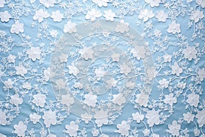 subtle texture of white floral lace on a pastel blue background