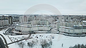 Suburb of a big city. City block from the height of the flight. City highway with busy traffic. Winter cityscape. Aerial photograp