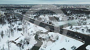 Suburb of a big city. City block from the height of the flight. City highway with busy traffic. Winter cityscape. Aerial photograp