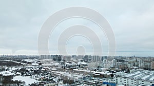 Suburb of a big city. City block from the height of the flight. City highway with busy traffic. Winter cityscape. Aerial photograp