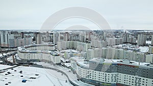 Suburb of a big city. City block from the height of the flight. City highway with busy traffic. Winter cityscape. Aerial photograp