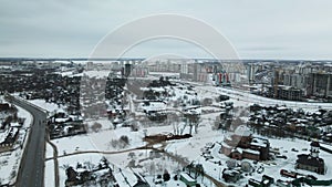 Suburb of a big city. City block from the height of the flight. City highway with busy traffic. Winter cityscape. Aerial photograp