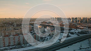 Suburb of a big city. City block from the height of the flight. City highway with busy traffic. Winter cityscape. Aerial photograp