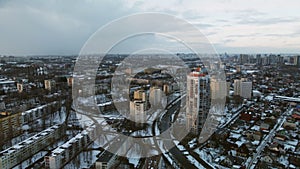 Suburb of a big city. City block from the height of the flight. City highway with busy traffic. Winter cityscape. Aerial photograp