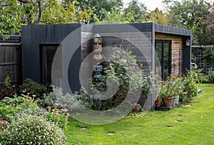 Suburban garden in Pinner, Middlesex, with sustainable eco friendly garden studio room with green living sedum roof.