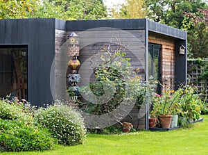 Suburban garden in Pinner, Middlesex, with sustainable eco friendly garden studio room with green living sedum  roof.