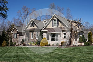 Suburban home with a stone and brick exterior and nice landscaping in a neighborhood in North Carolina