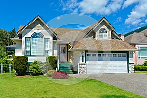 Suburban house with concrete driveway and blue sky background. House for sale