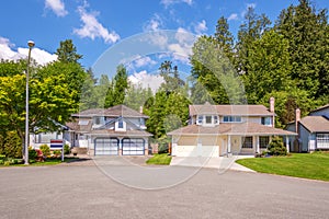 Suburban residential street with houses for sale sign