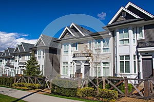 Suburban residential street townhomes. On bright sunny spring day against bright blue sky.