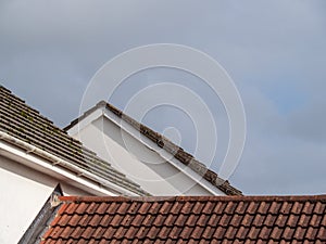 Suburban UK roofs, red tiles, grey sky.