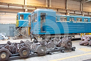 Subway passenger car locomotive, electric transport in the depot on suspended jacks for service. Wheelsets nearby