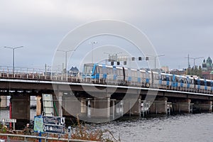 Subway train travels over a bridge over a river