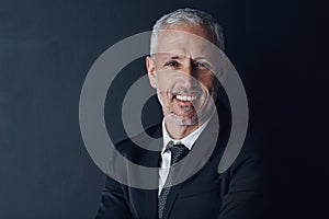 Succeeding in business with sincerity. Studio portrait of a mature businessman against a dark background.