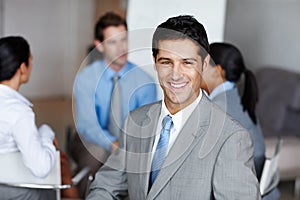 Succeeding in every possible way. A handsome executive smiling at you confidently during a business presentation.