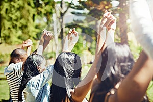 Succeeding in solidarity. Rearview shot of a group of young friends raising their hands in triumph.