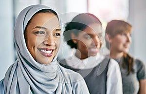 Succeeding together. Portrait of a group of young confident businesswomen standing in a row behind each other inside of